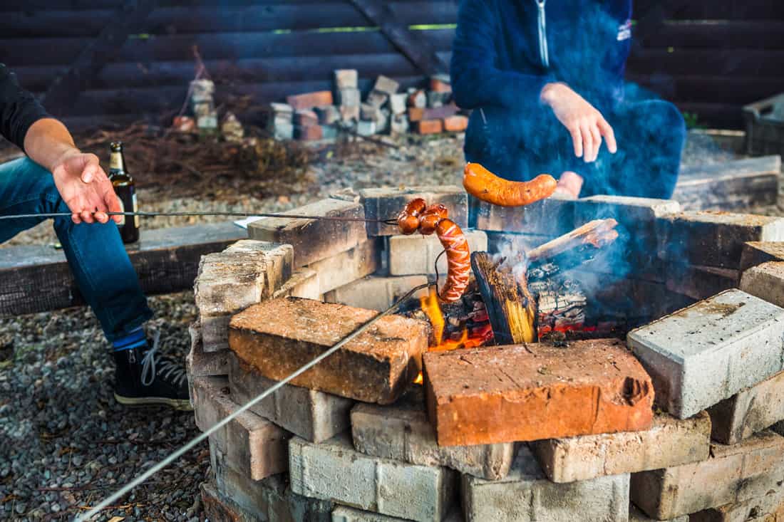 Campfire (bonfire) - people roasting sausages — Photo