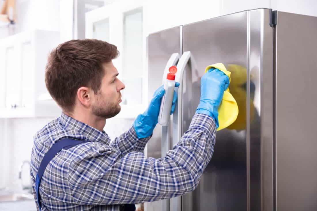 Clean The Door Of The Refrigerator - Man Wearing Rubber Gloves Cleans