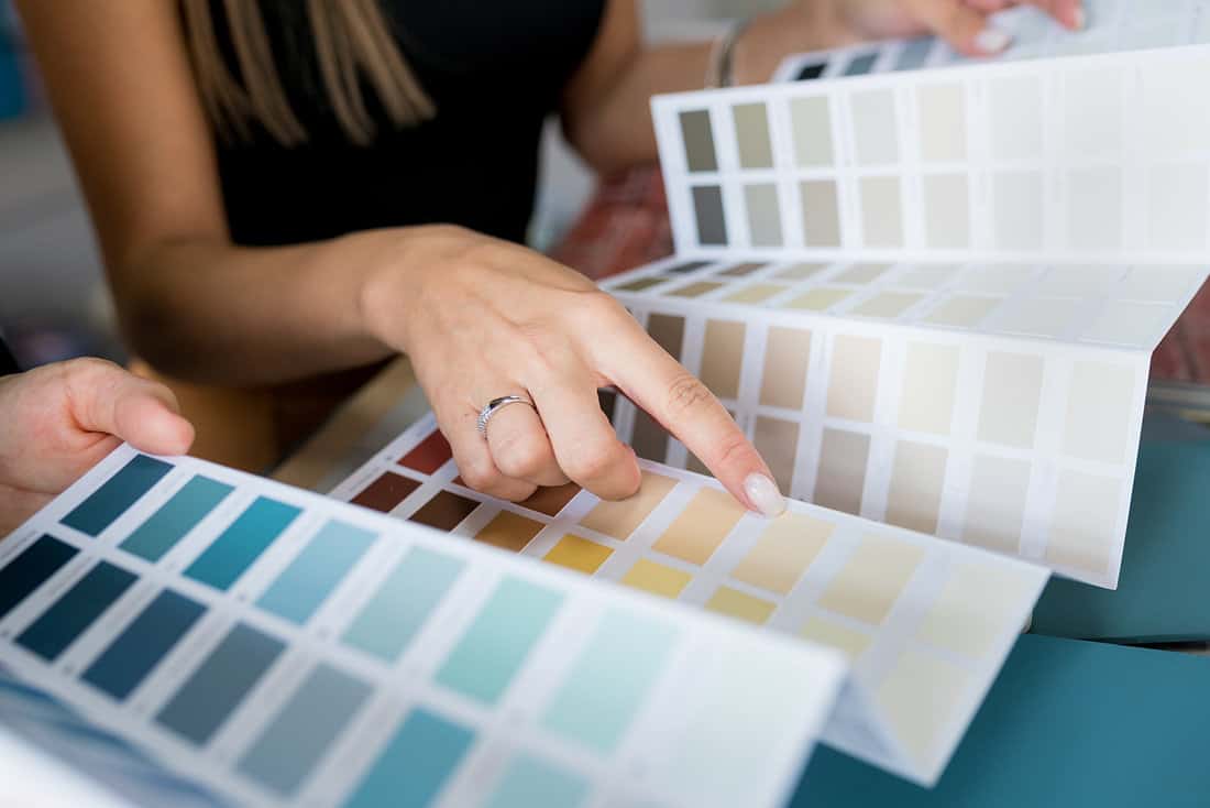Close-up of women choosing samples of wall paint