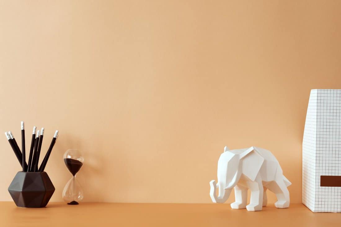 Creative orange pastel desk with copy space, elephant figure. Empty pastel wall. Minimalistic concept. Template. Stylish and modern composition of home decor. — Photo