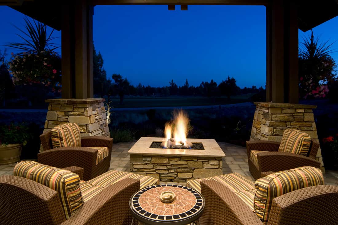 Deck with fire pit, outdoor furniture, and with a beautiful evening setting.