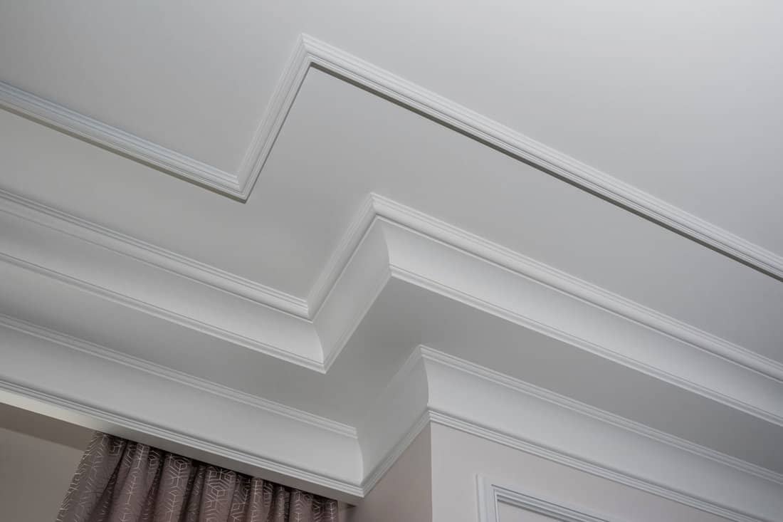 Detail of intricate corner crown molding of a corner of a ceiling