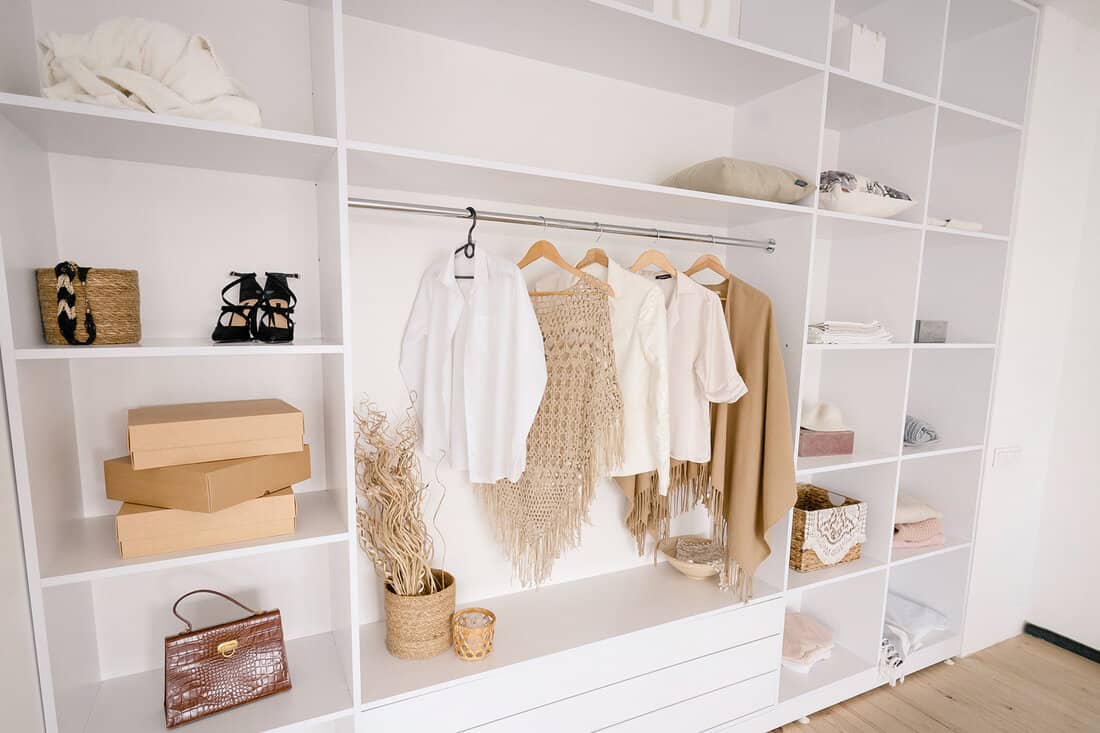 Female Fashionable Stylish Wardrobe. A Large White Built-in Wardrobe Stocked With Women's Clothing, Shoes and Accessories. Walk-in closet, Dressing Room for Women. High quality photo