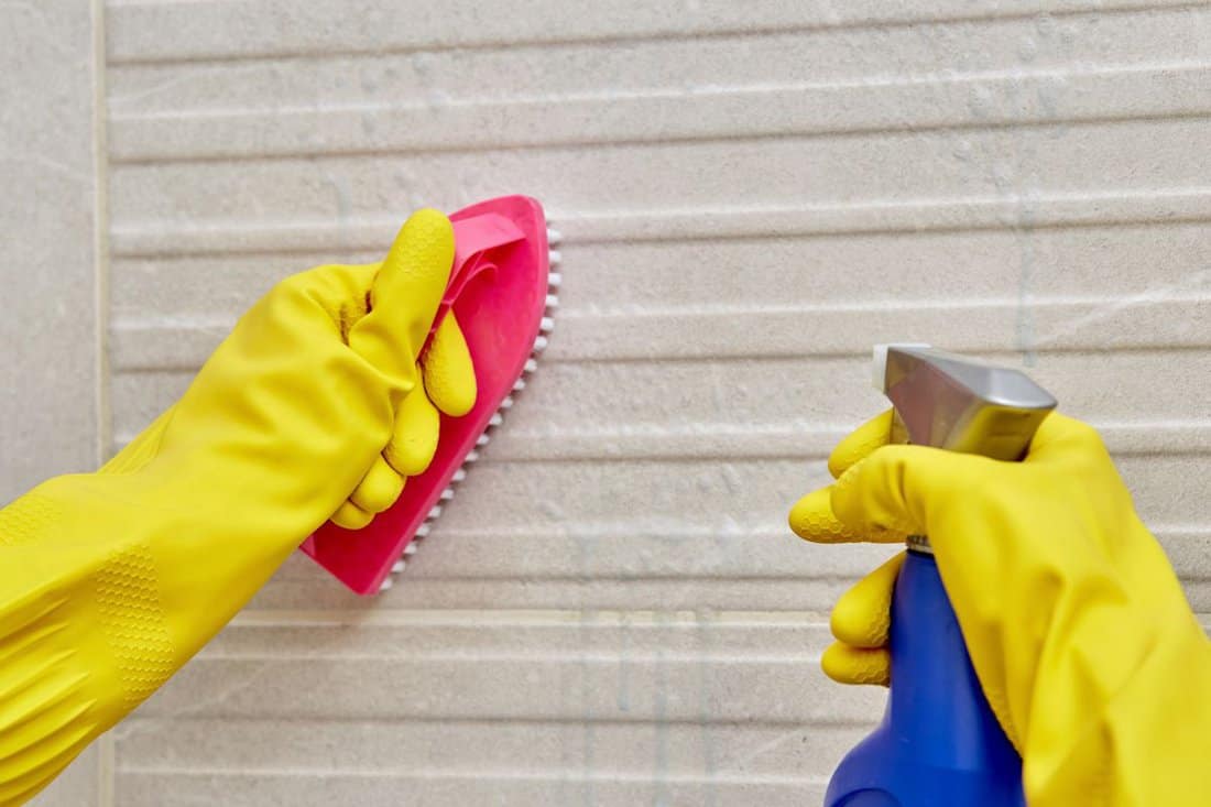 Female hand in a protective yellow glove with a brush. Cleaning the bathroom. — Photo