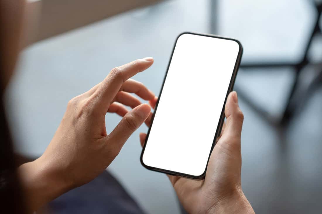 Hand holding a smartphone white screen is blank