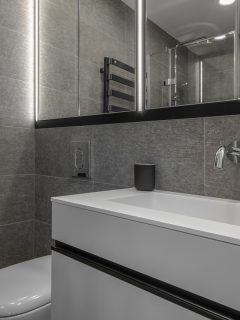 Interior of an ultra gray themed bathroom with white tiled vanity and a huge long span mirror, What Color Shower Curtain For A Gray Bathroom?