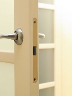 Metal handle of white door in room