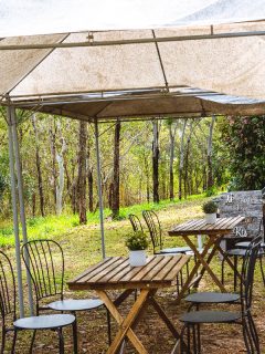 An outdoor cafe dining with a hillside lean, rustic table and chairs under a mildewed tent, How To Keep Outdoor Curtains From Mildewing
