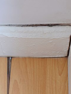 Parquet or wooden floor in the room with floor damaged by destructive elements from moisture or water, Water Coming From Baseboard When It Rains - What To Do?