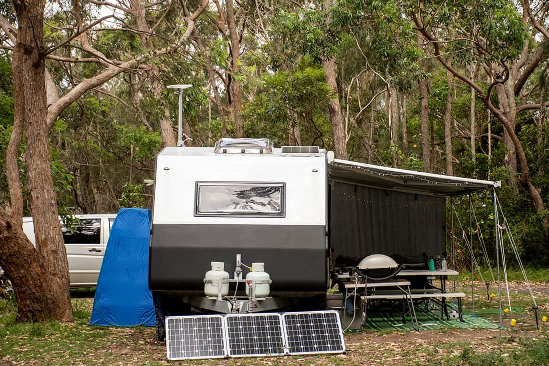 RV caravan camper on a campsite in the bush forest nature
