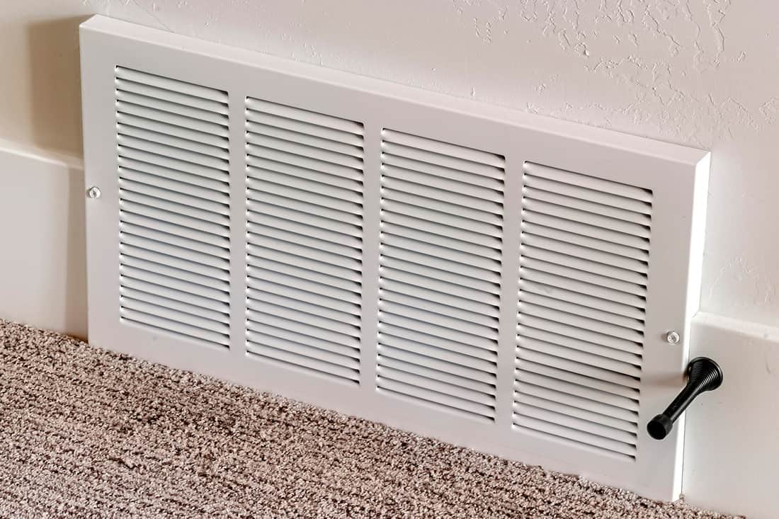 Square Air conditioner white plastic grille cover against wall and carpet floor