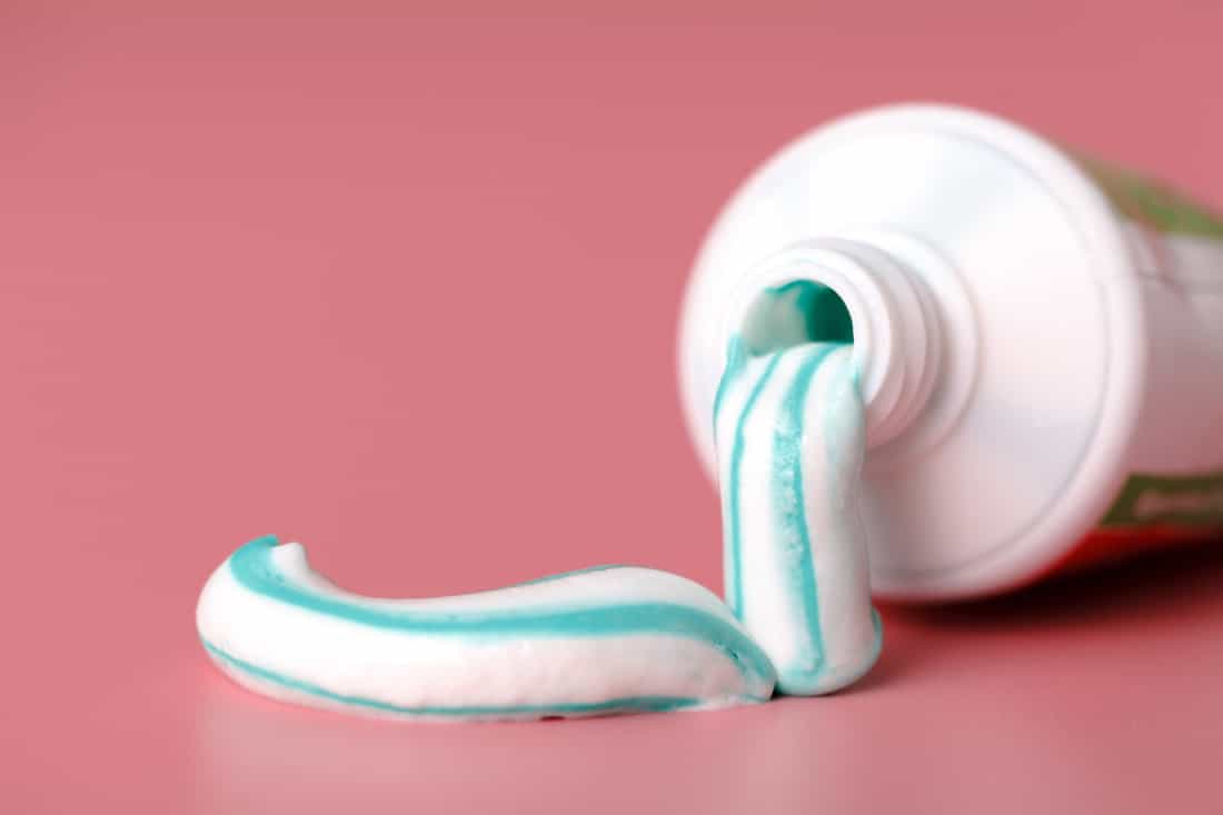Tooth paste close up on pink background
