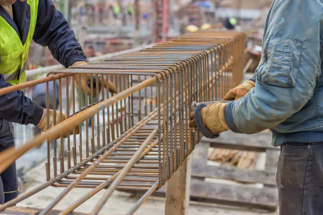 Workers hands fixing steel reinforcement bars 2