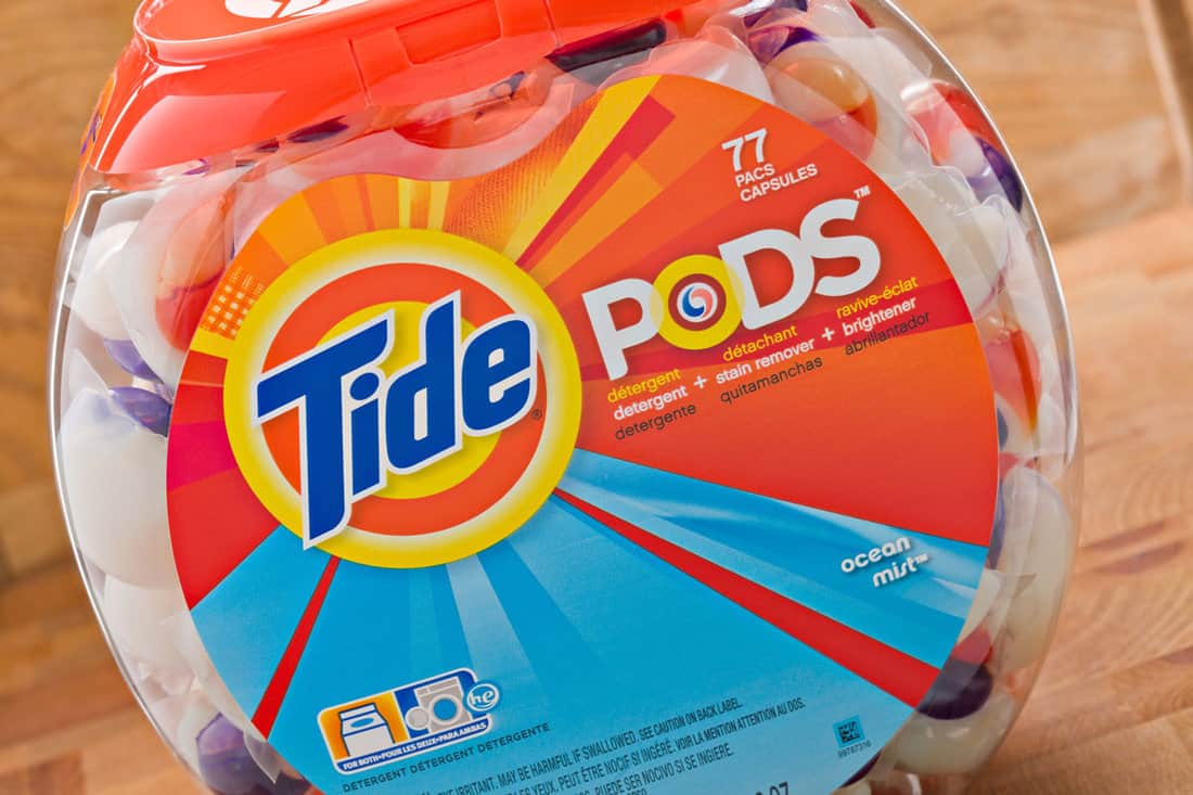 a fish bowl shaped plastic vessel containing 77 Tide Pods capsules