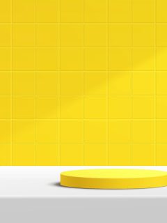 a photo of a yellow tile on the wall, white table, yellow plate on the white table, What Color Goes With Yellow Tile?