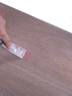carpenter scraping excess wooden filler on the cracks using a chisel, Does Wood Filler Act As Glue? [And Which To Choose]