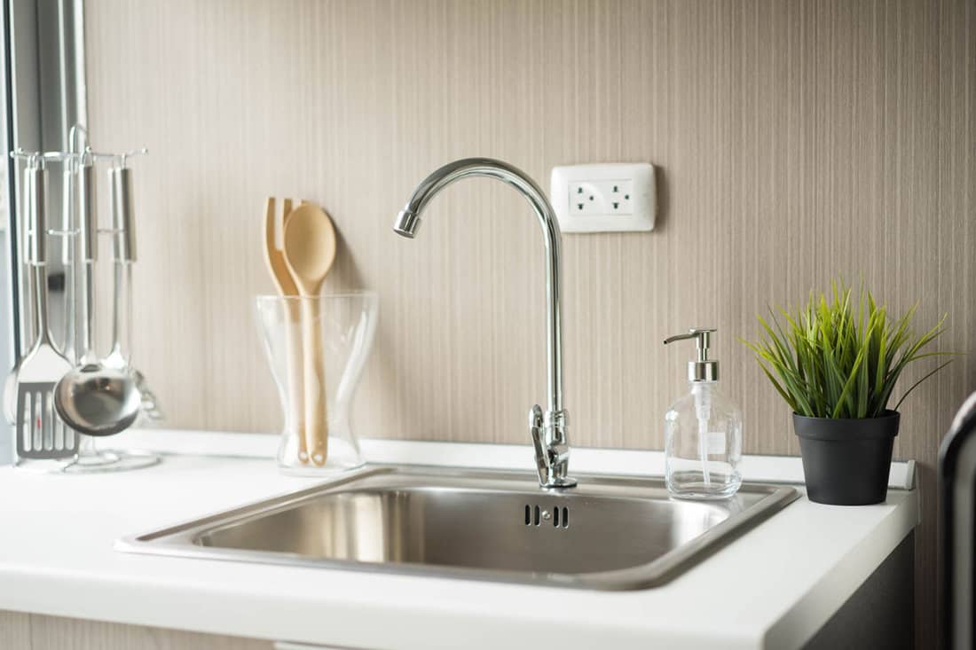 elegant modern kitchen sink design, minimalist, wood textured wall, stainless sink