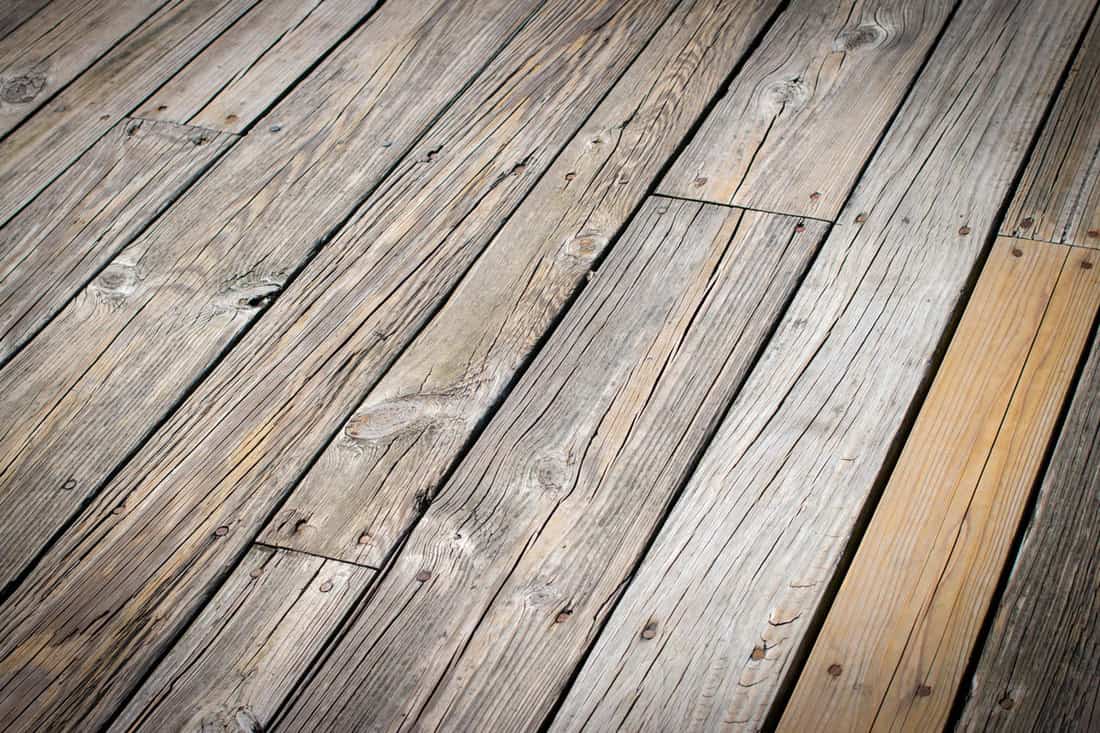 old wood deck on the floor, with old nails, brown dry wood decks