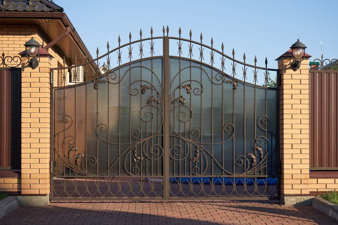 photo of a nice good looking huge classic gate design with privacy screen on it