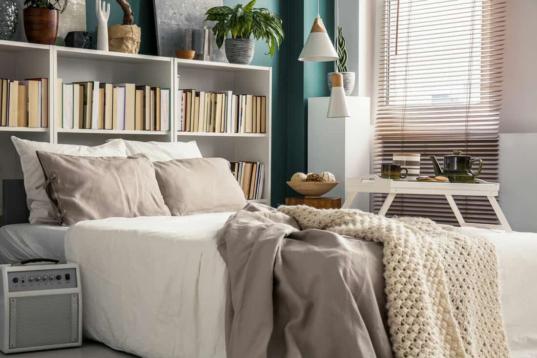 small space in a stylish bedroom interior with designer decor and cozy white and beige bedding