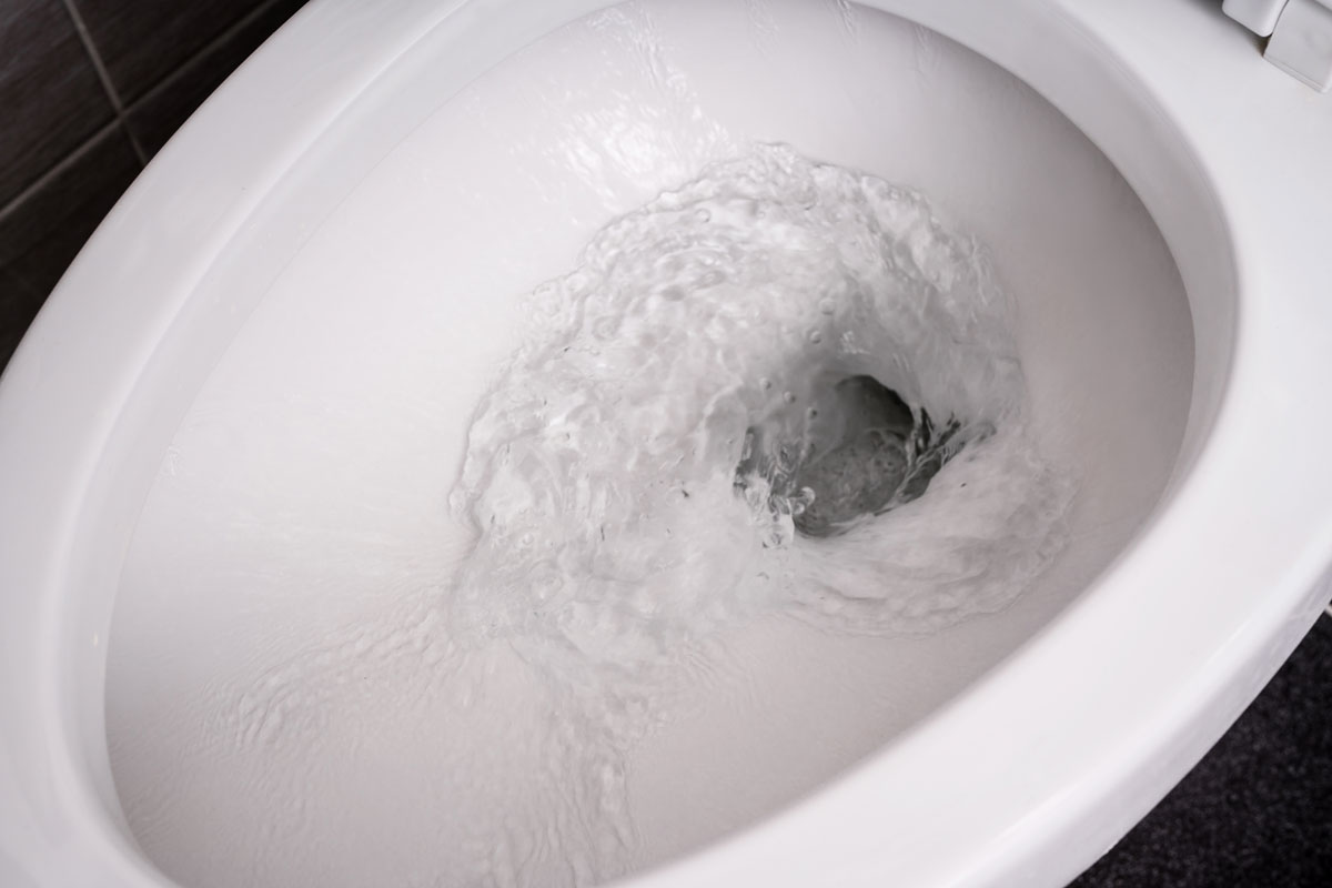 toilet bowl flushing water, up close photo, white toilet bowl