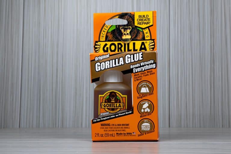 up close photo of a gorilla glue with box including good packaging, grey background pictorial, Can You Use Gorilla Glue On Metal? [And How]
