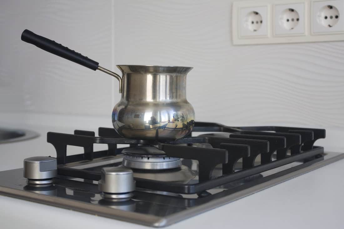 urk for coffee on the metal gas stove «Whirpool» on modern kitchen