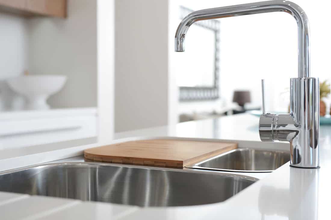 very clean stainless steel sink of the kitchen of the house, silver stainless faucet