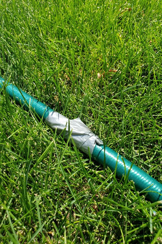 yard garden hose with a leak fixed with duct tape