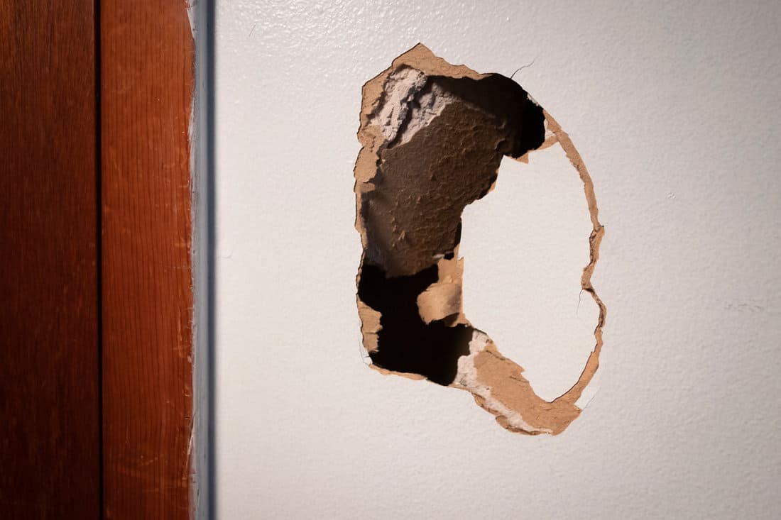 A huge hole on the drywall inside a room