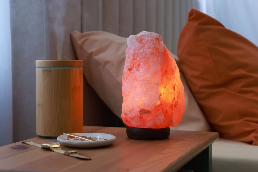 A Himalayan rock salt lamp on the bedside table