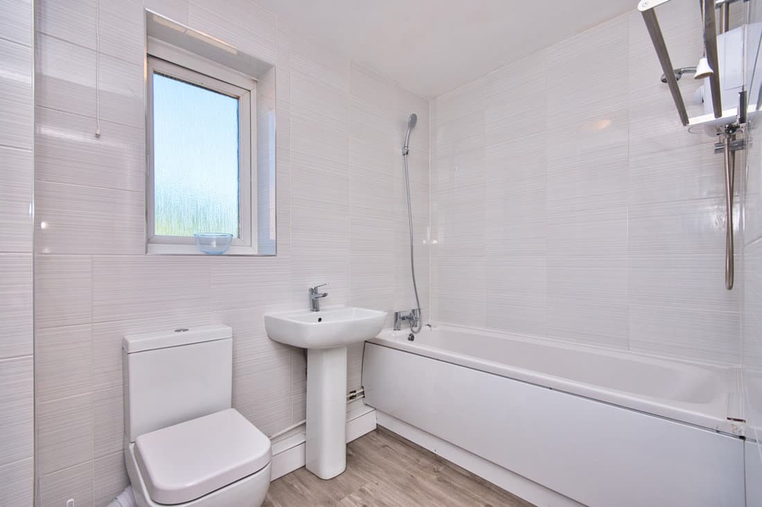 Brand New Refurbished contemporary Bathroom suite with fully tiled walls and grey vinyl flooring in London UK