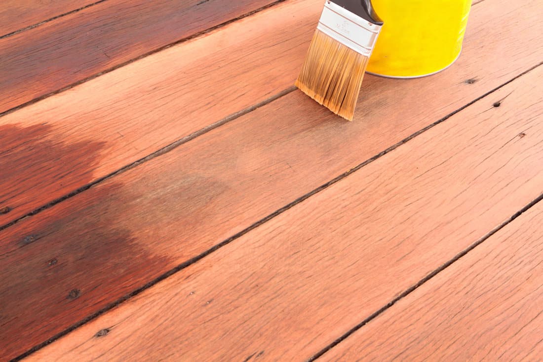 Brush tin and decking oil for a timber deck.