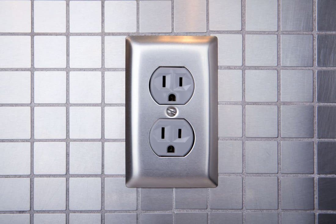 Brushed aluminum outlet with brushed stainless steel tiled wall.