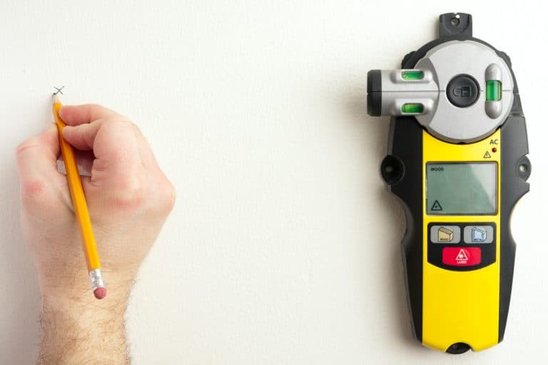 Carpenter marking the wall where a stud is placed, How To Use A Stanley Stud Finder [Step By Step Guide]