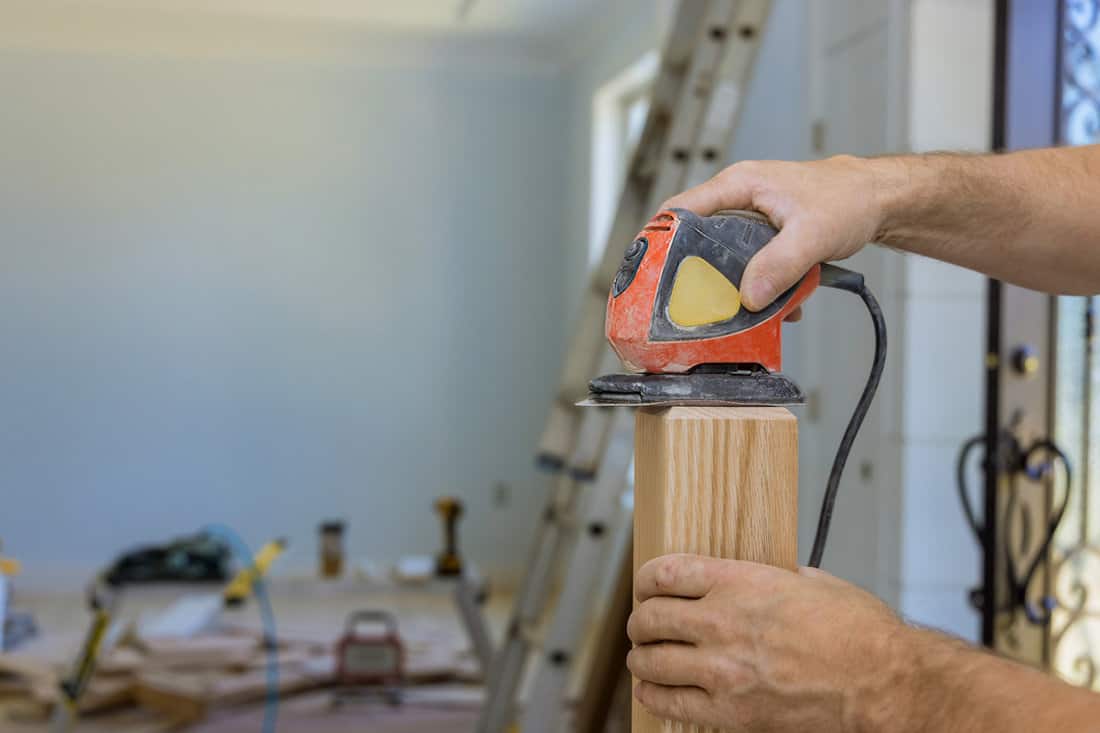 Carpenter using power sander on his project