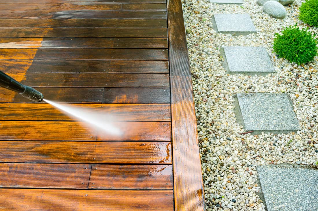 Cleaning terrace with a pressure washer wood deck floor