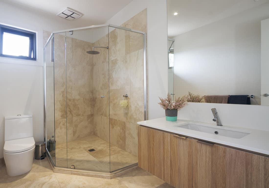 Corner shower marble tiling in contemporary bathroom in luxury house