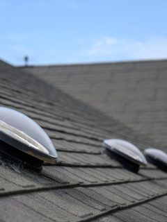 Dome shaped solar tube skylight on asphalt shingle roof