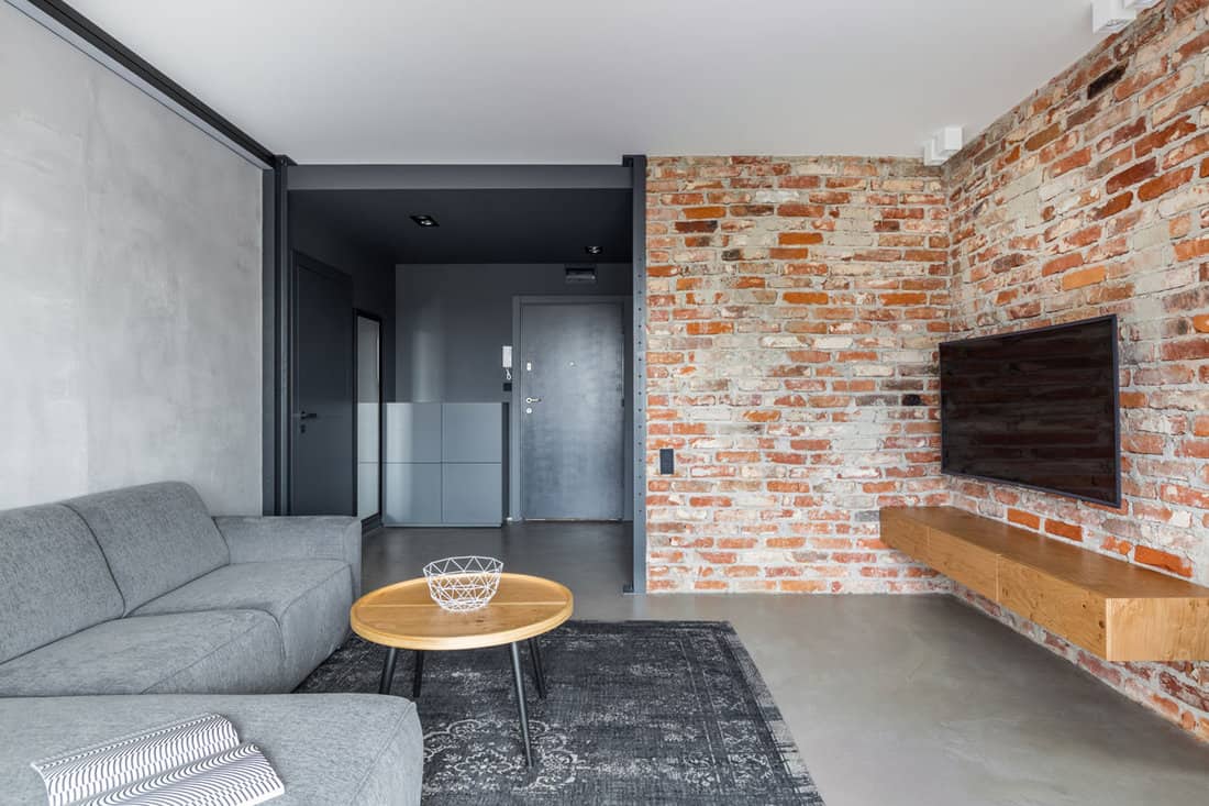 Exposed brick wall and concrete floor in industrial living room