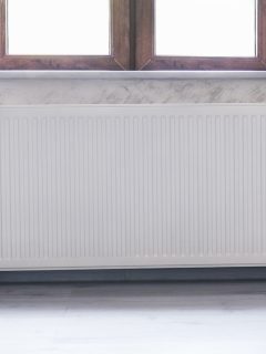 Heating radiator under the window with a wooden frame and curtains - Where Should Curtains Sit Above A Radiator