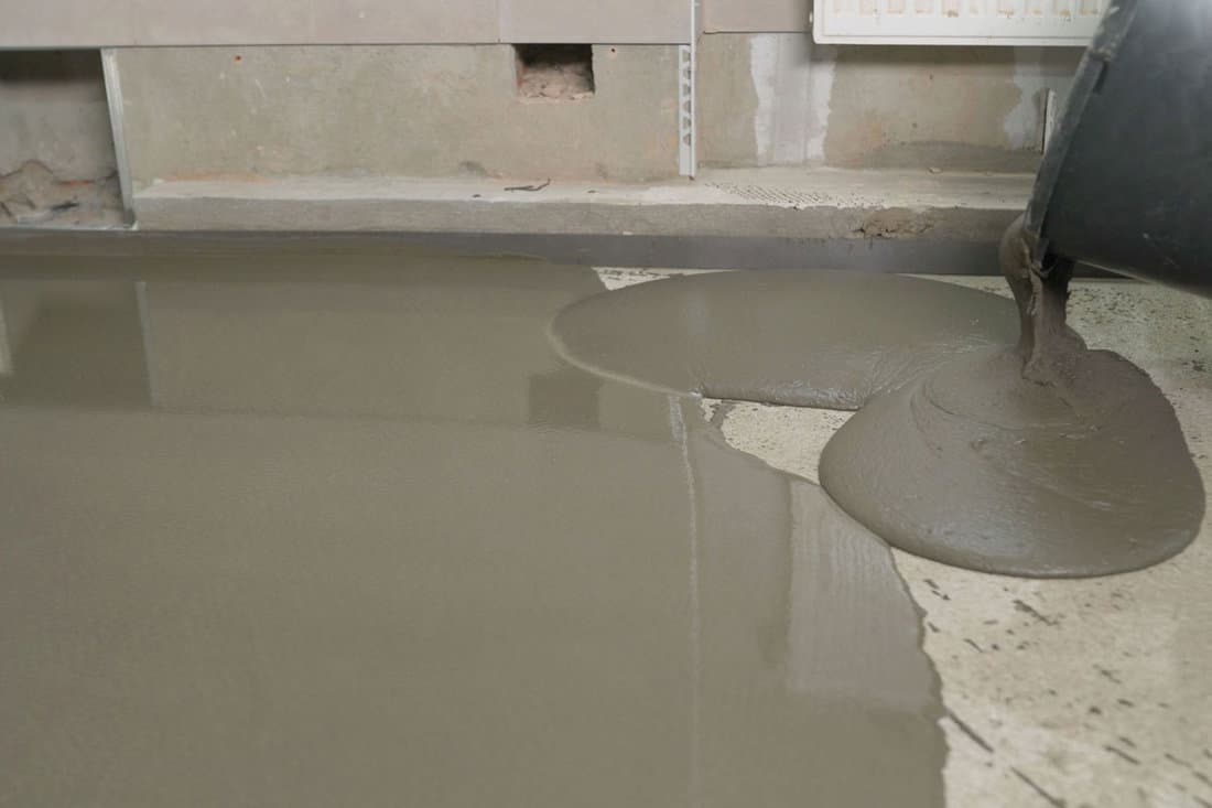 Leveled dry cement-sand mixture on the floor surface in a building under construction