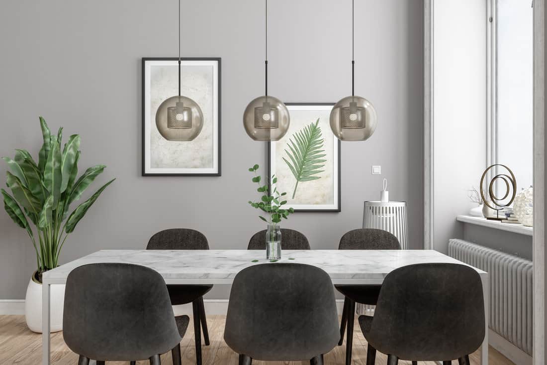 Modern Dining Room With Marble Dining Table, Pendant lights, Plants And Posters