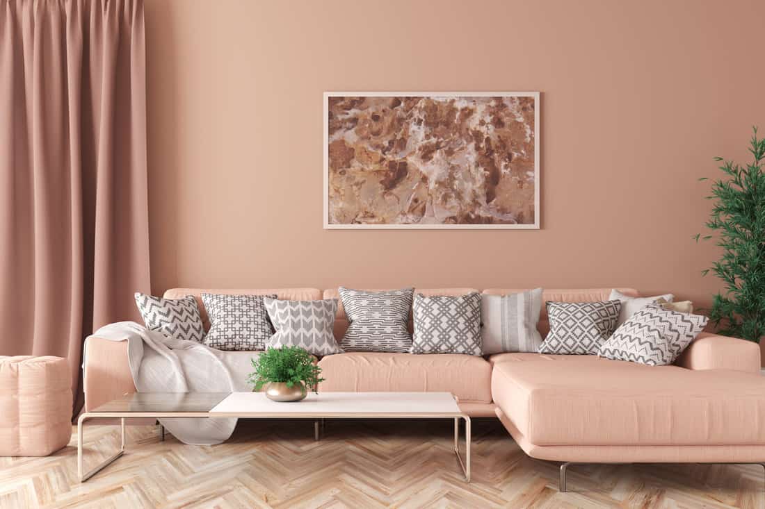 Modern interior of living room with peach corner sofa, coffee table 