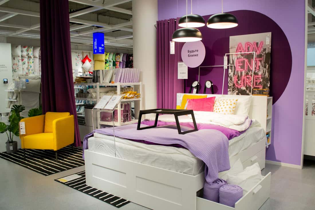 Moscow, Russia, September 2019 Bedroom with purple walls, a white linen, pink pillow and a pattern of yellow polka