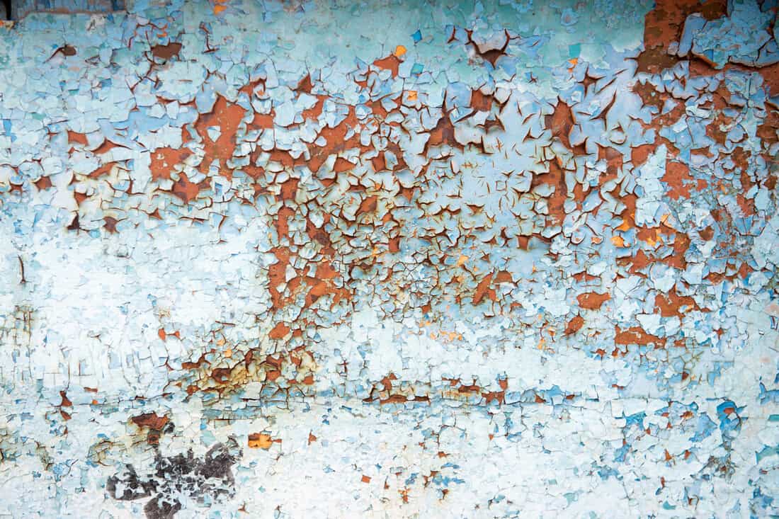 Old wall with blue peeling paint