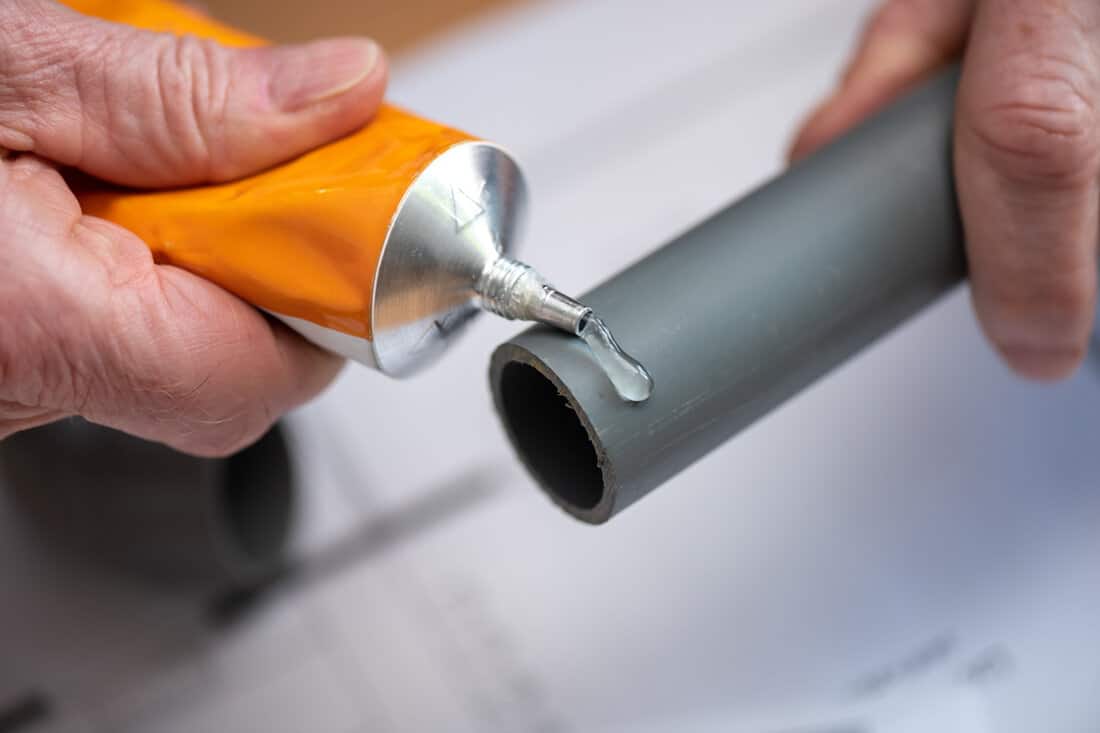Plumber putting glue on a pvc pipe