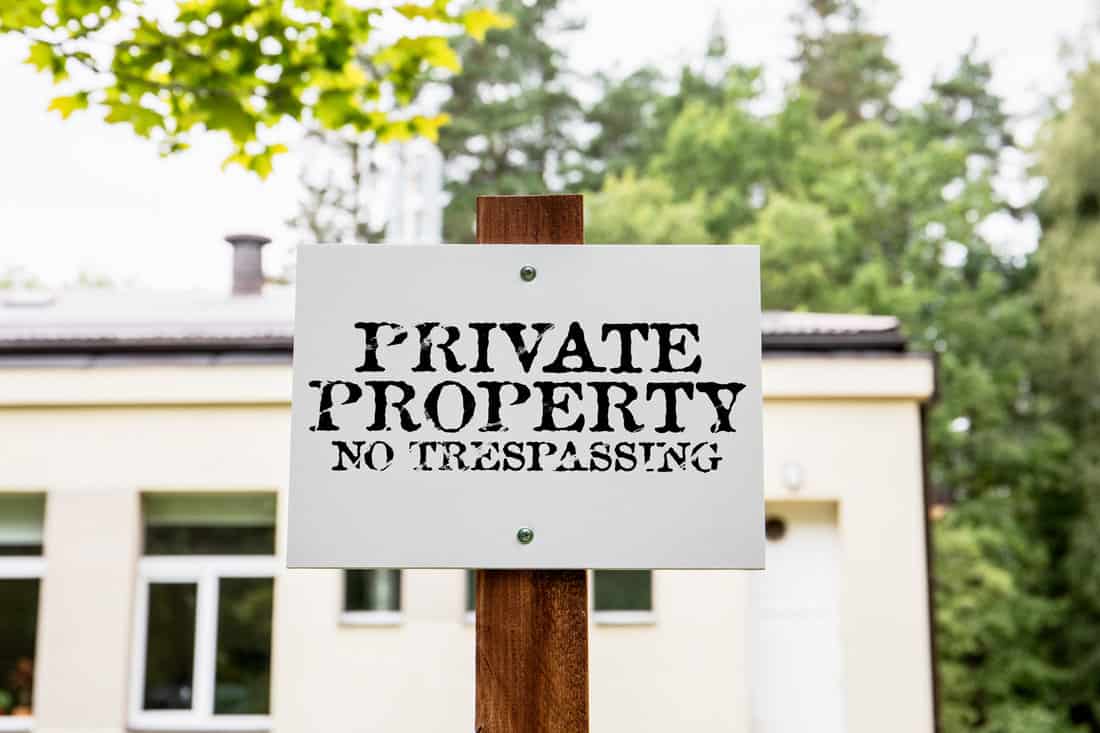Private property no trespassing. White sign next to the property.