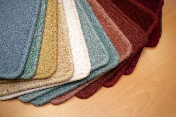 Samples of carpet coverings in shop, Should I Dye My Carpet? [Pros & Cons For Homeowners]