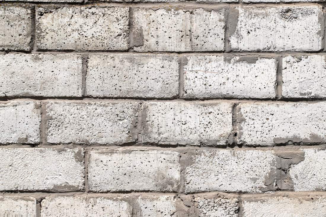 Texture of an old white wall made of rough ceramsite concrete blocks as a background